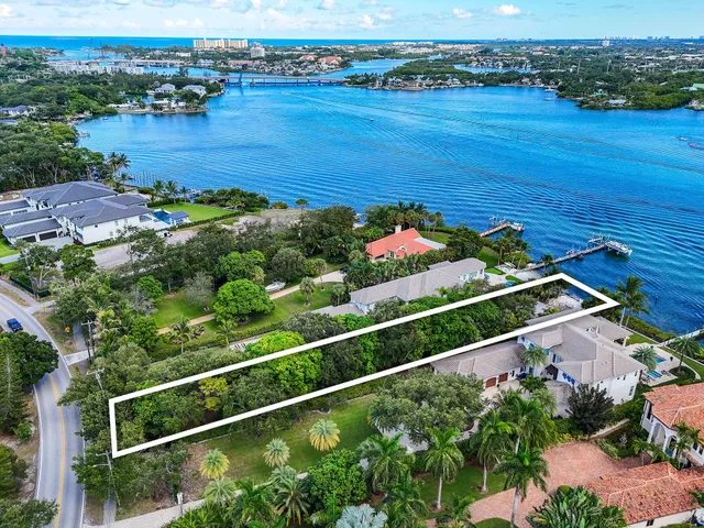 an aerial view of ocean and residential houses with outdoor space