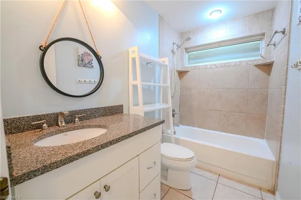 a bathroom with a granite countertop sink toilet mirror and shower