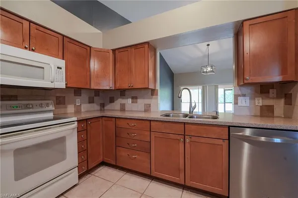 a kitchen with cabinets a sink and appliances