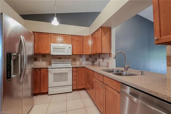 a kitchen with stainless steel appliances granite countertop a sink and a refrigerator