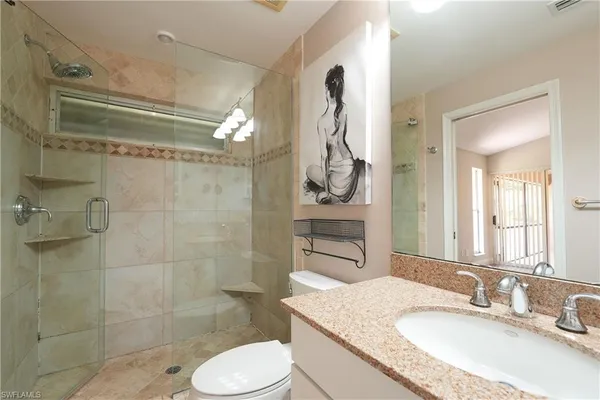 a bathroom with a granite countertop sink toilet and shower