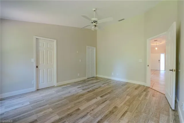 a view of a big room with wooden floor and a ceiling fan