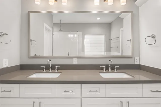 a bathroom with double vanity sinks and a mirror
