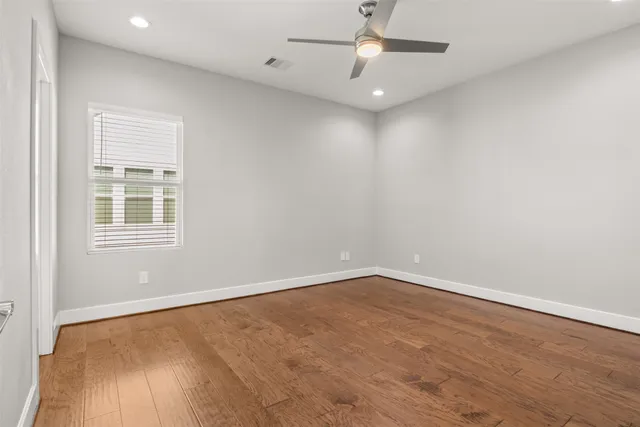 an empty room with a window and ceiling fan