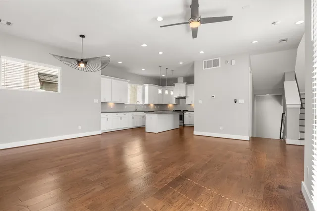 a view of an empty room and kitchen view