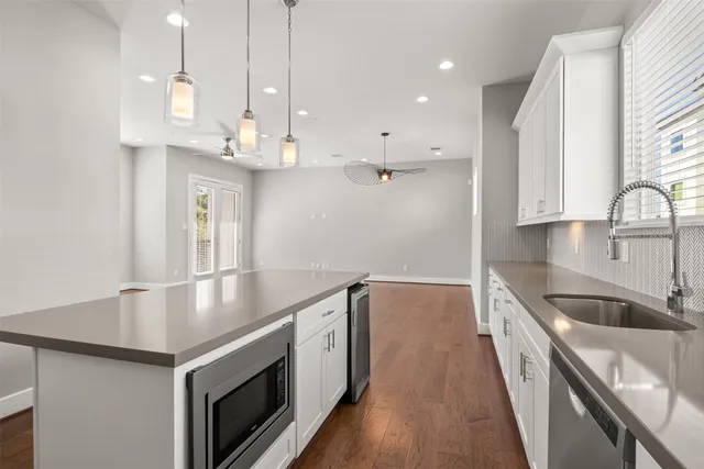 a kitchen with stainless steel appliances granite countertop a sink a stove and a wooden floors