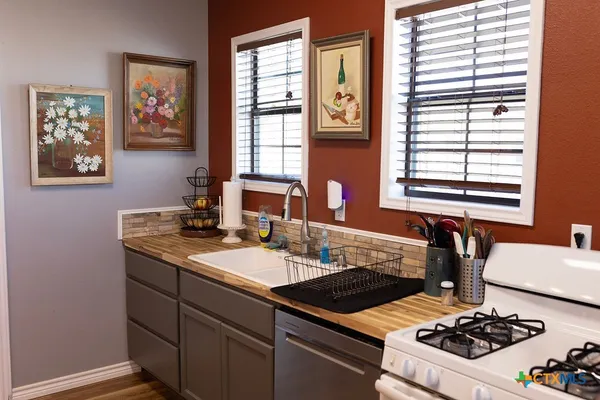 a kitchen with a stove a sink and a window