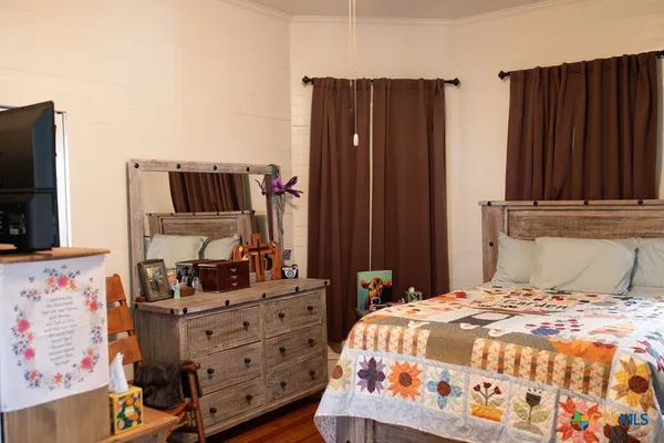 a bedroom with a bed and a flat tv screen on dresser