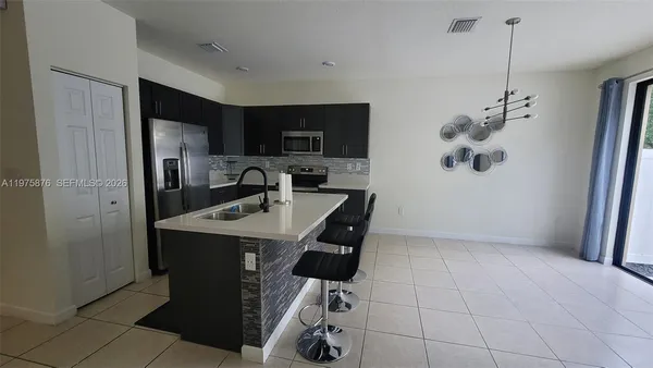 a kitchen with kitchen island a sink stainless steel appliances and cabinets