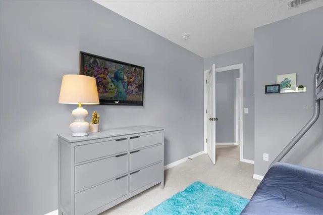 a bed sitting in a bedroom next to a wall with wooden floor