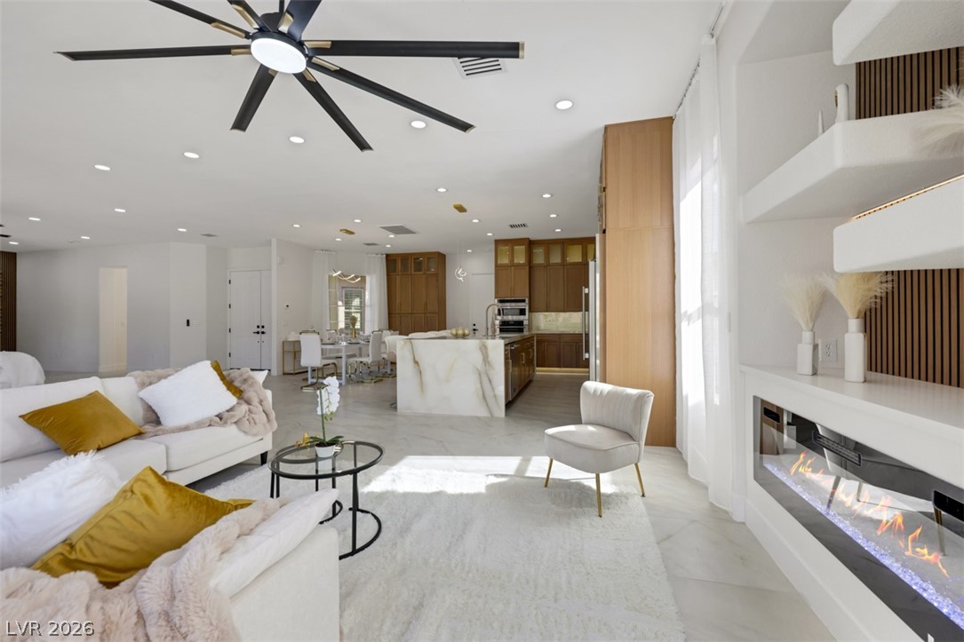 5015 Rivedro Street Las Vegas, NV 89135 - Photo 27 of 91 An open concept living area features recessed lighting, elegant marble flooring, and a contemporary fireplace.