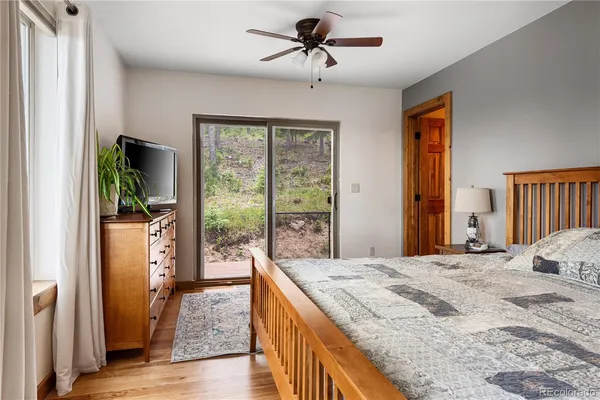 a bedroom with a bed and a large window with the outer view