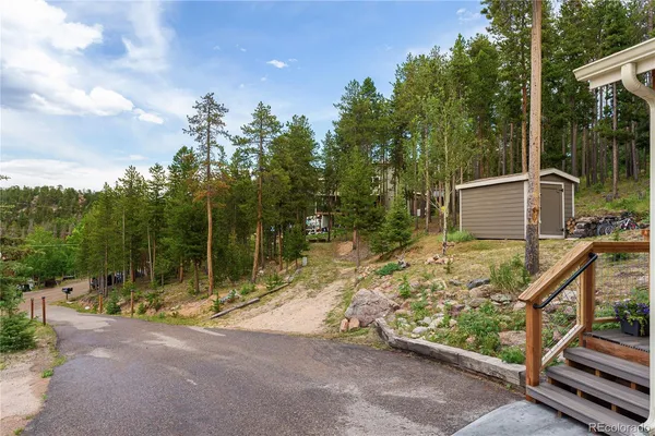 a view of a house with backyard and trees