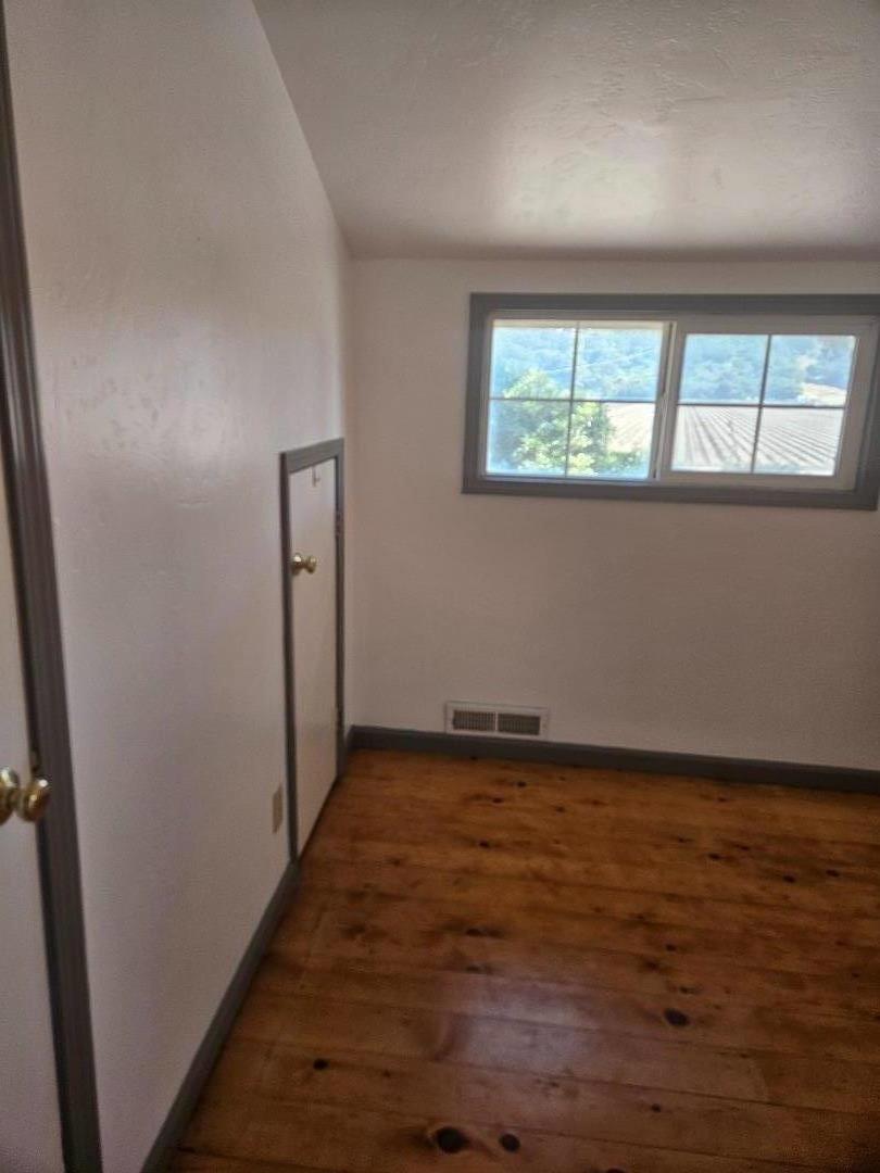 120 Trafton Road Watsonville, CA 95076 - Photo 15 of 43 an empty room with wooden floor and windows