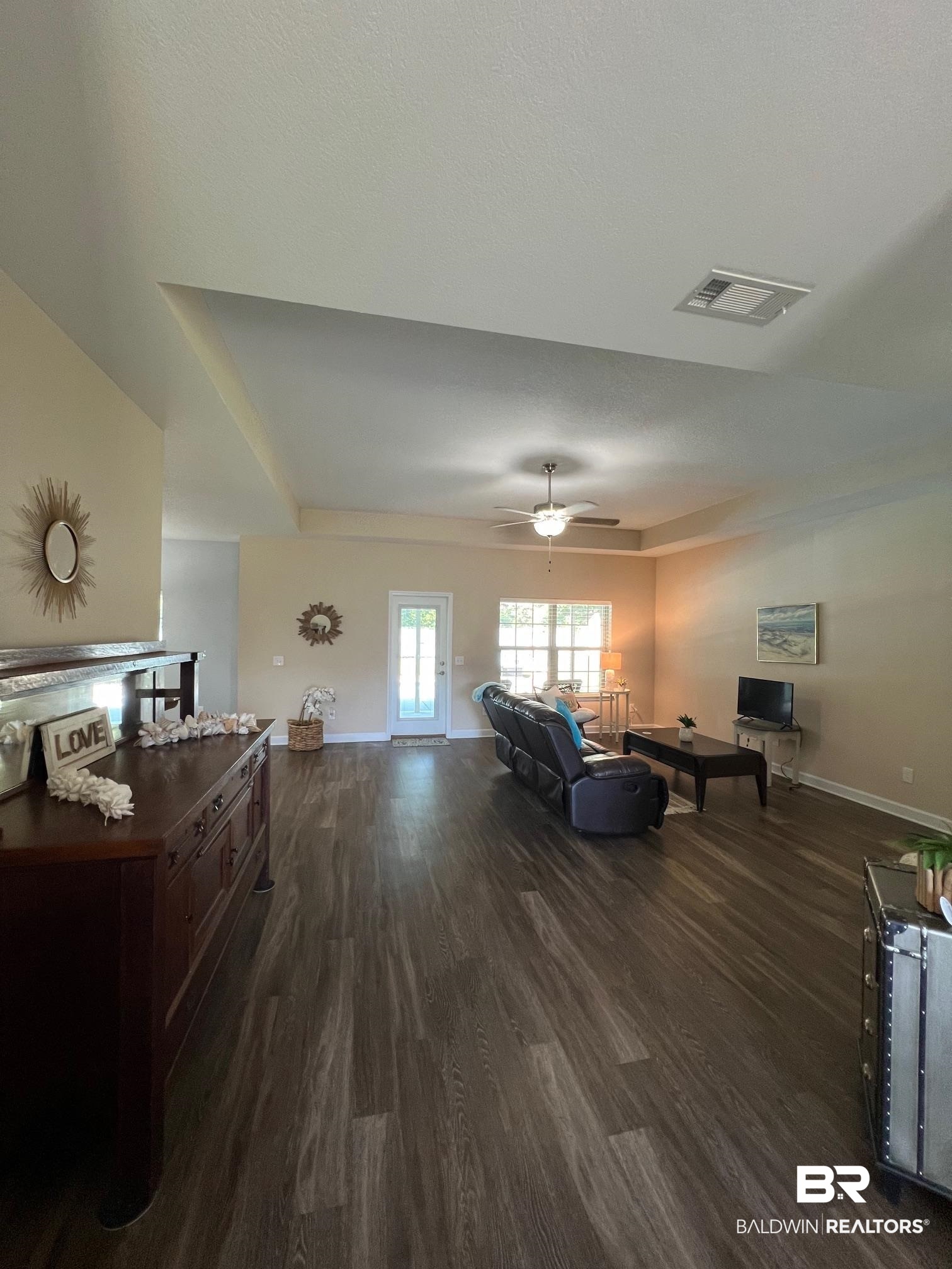 10257 Lyttleton Loop Lillian, AL 36549 - Photo 5 of 31 Living room featuring dark wood-style floors, a tray ceiling, ceiling fan, and a textured ceiling
