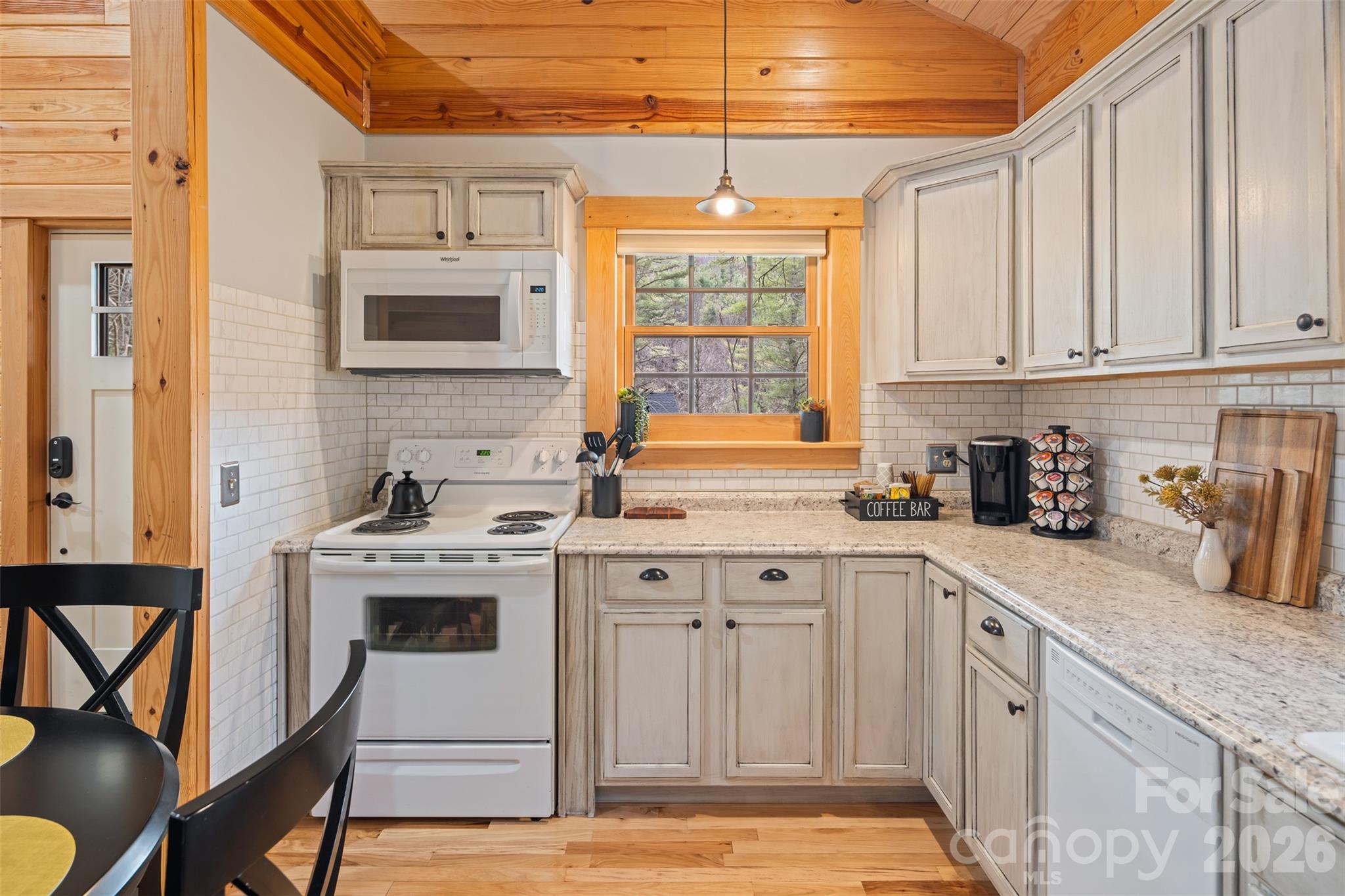 1333 Park Vista Road West Jefferson, NC 28694 - Photo 12 of 39 a kitchen with stainless steel appliances granite countertop a stove a sink dishwasher and white cabinets with wooden floor