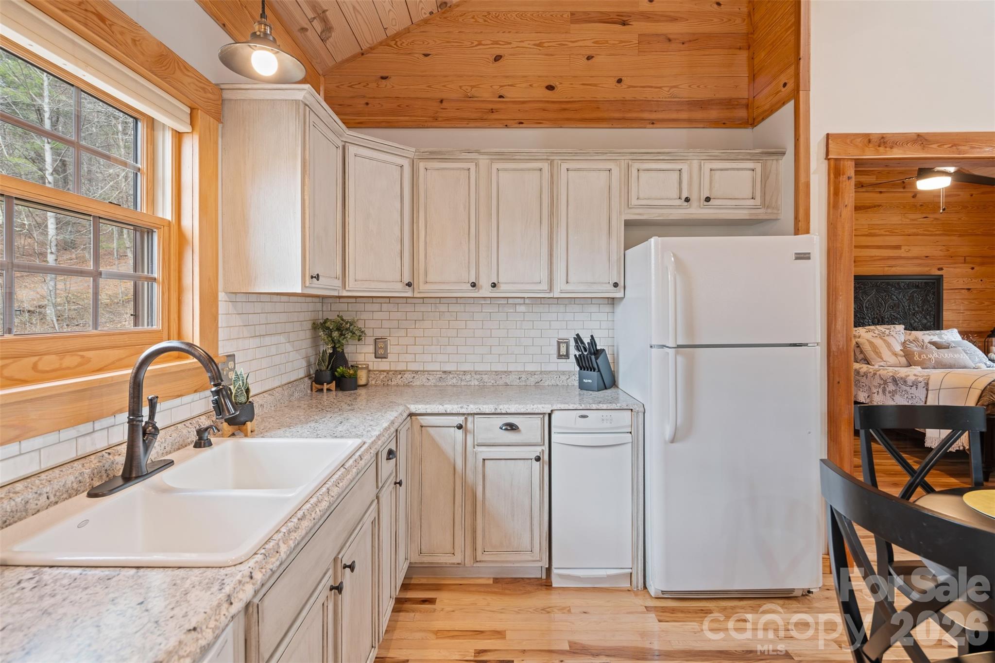 1333 Park Vista Road West Jefferson, NC 28694 - Photo 14 of 39 a kitchen with stainless steel appliances granite countertop a refrigerator a sink a stove a dining table and chairs with wooden floor