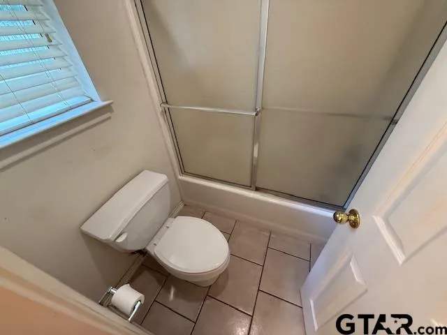 a white toilet sitting next to a shower