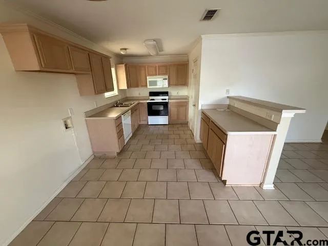 a kitchen with a sink a stove top oven and cabinets
