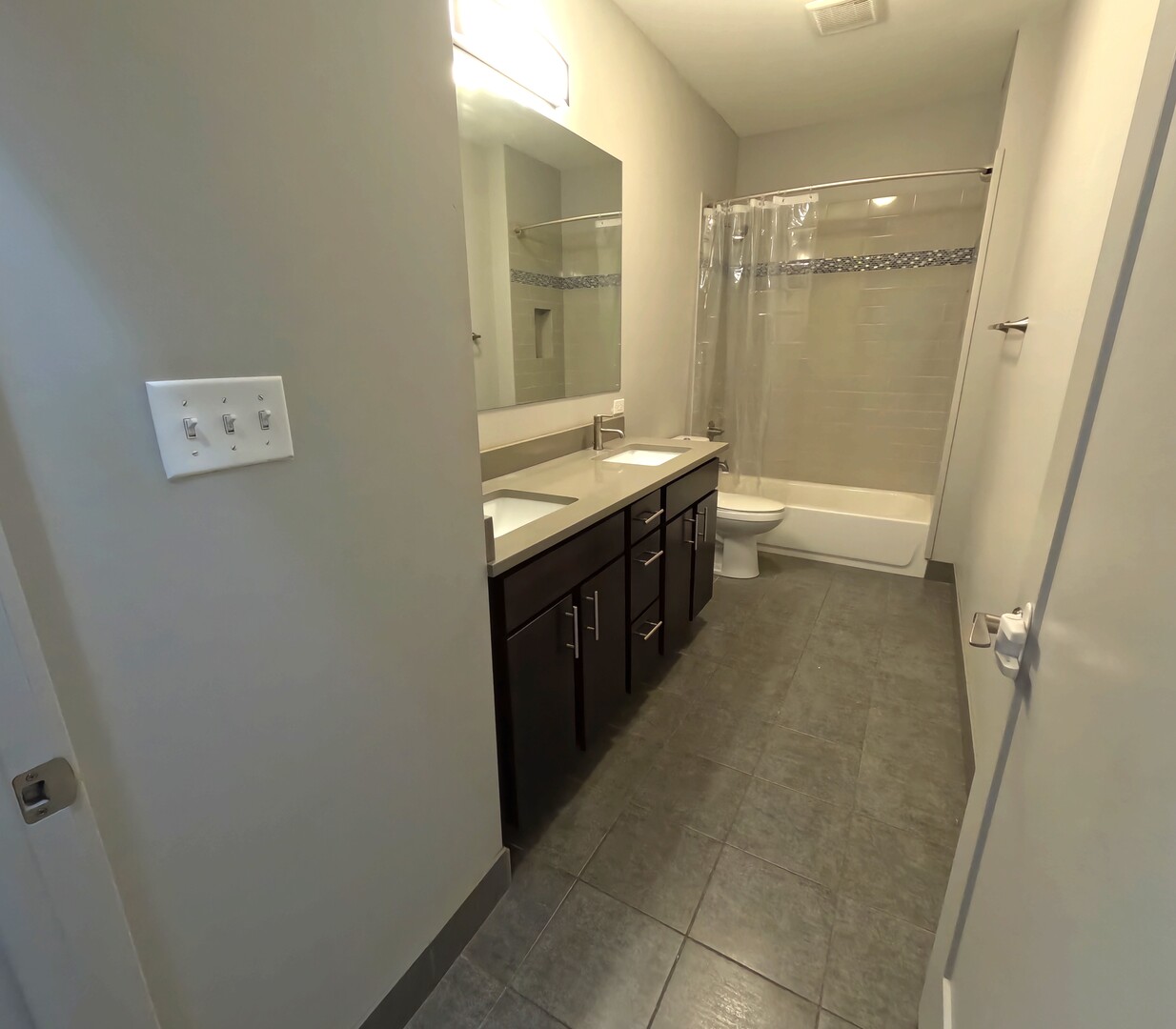 1432 West 21st Street, Unit 321 Chicago, IL 60608 - Photo 3 of 25 a bathroom with a double vanity sink toilet mirror and bathtub