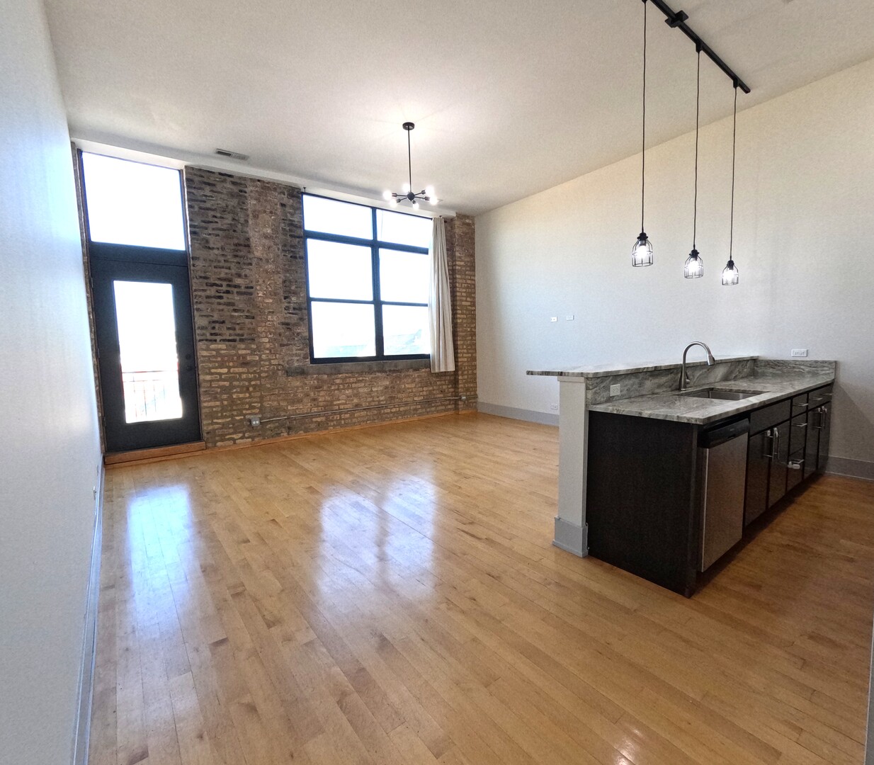 1432 West 21st Street, Unit 321 Chicago, IL 60608 - Photo 9 of 25 a kitchen with stainless steel appliances granite countertop a sink a stove and a wooden floors