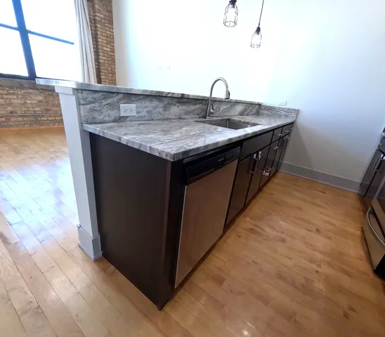 a kitchen with a sink cabinets and wooden floor