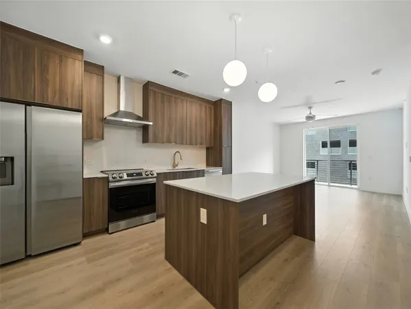 a large kitchen with a lot of counter space and wooden floor