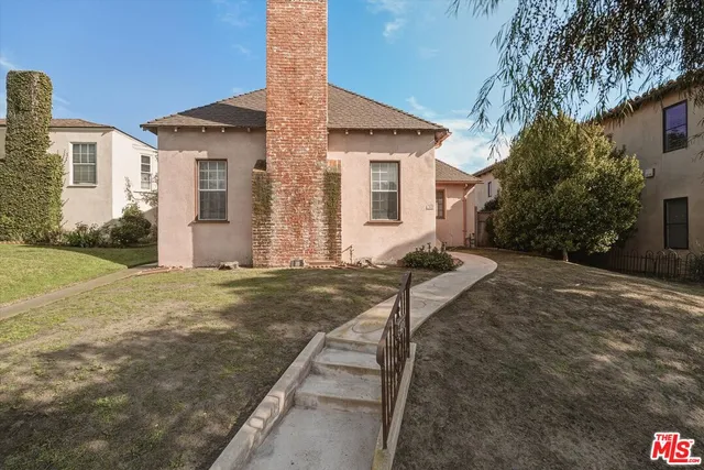 a view of a house with backyard and a tree
