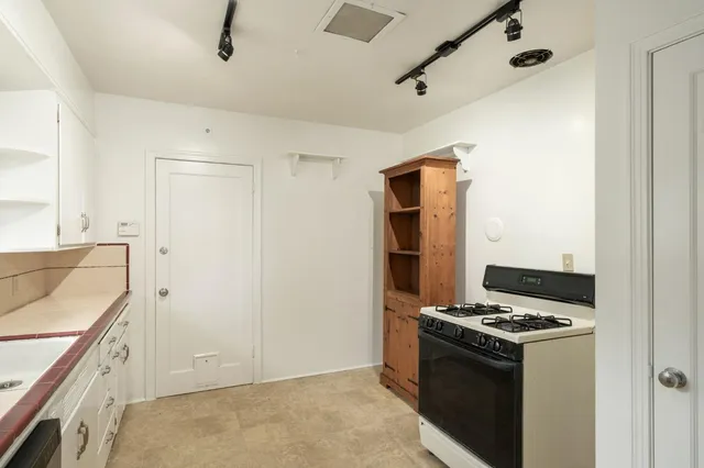 a kitchen with stainless steel appliances granite countertop a stove and a refrigerator