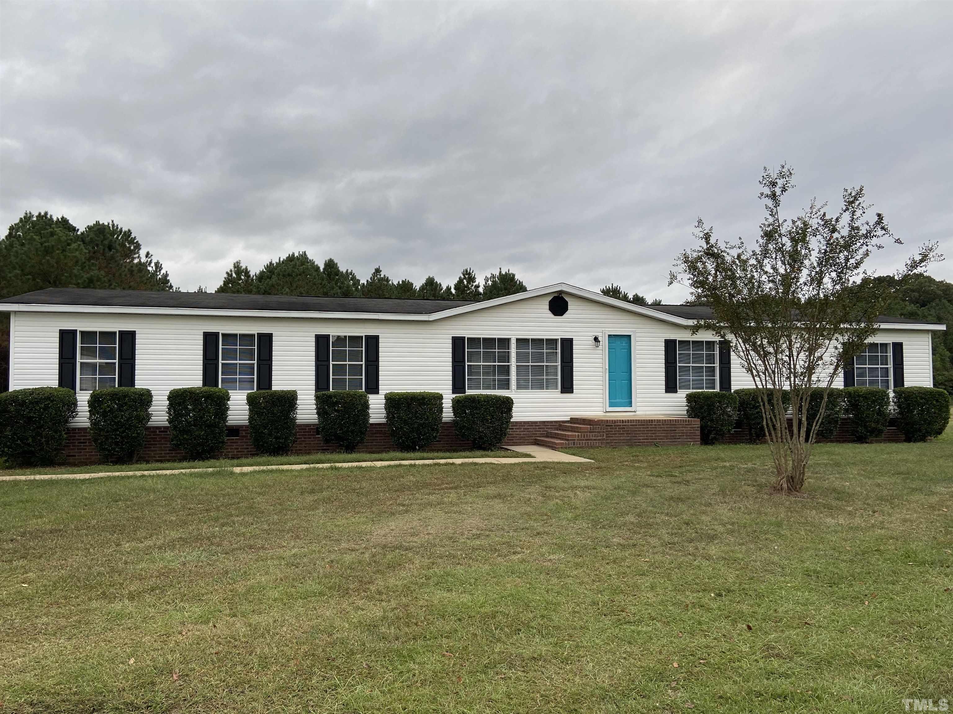 9969 Smith Road Middlesex, NC 27557 - Photo 2 of 19 a front view of a house with a garden and yard