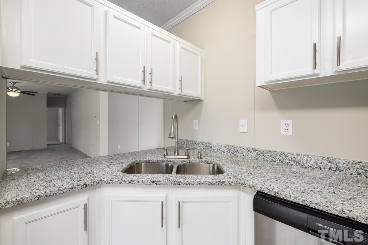 9969 Smith Road Middlesex, NC 27557 - Photo 6 of 19 a kitchen with granite countertop white cabinets and a sink