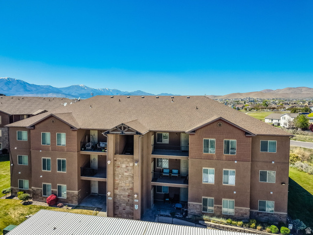 8215 Clear Rock Road, Unit 12 Eagle Mountain, UT 84005 - Photo 19 of 38 Multi-story apartment building featuring a brown stucco and stone facade with balconies