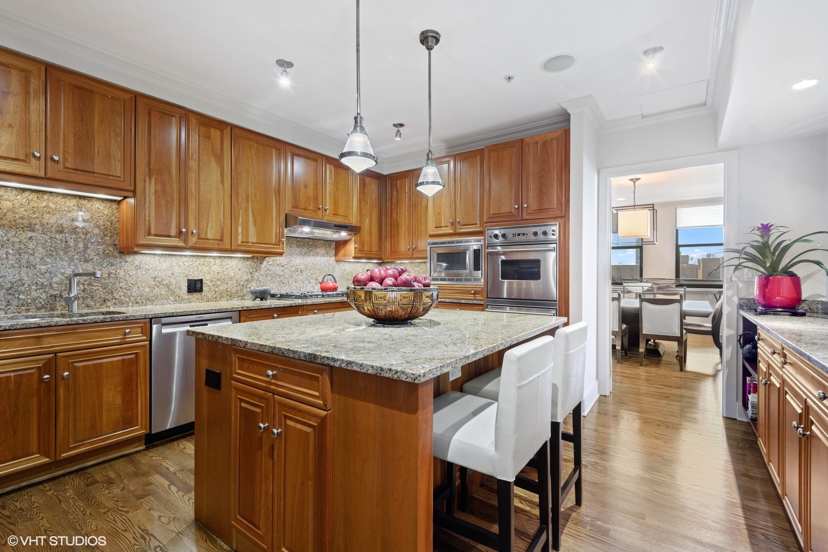 1155 North Dearborn Street, Unit 1003 Chicago, IL 60610 - Photo 5 of 28 a kitchen with stainless steel appliances granite countertop a kitchen island hardwood floor sink stove dining table and chairs