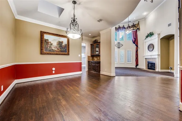a view of a livingroom with a chandelier wooden floor and windows