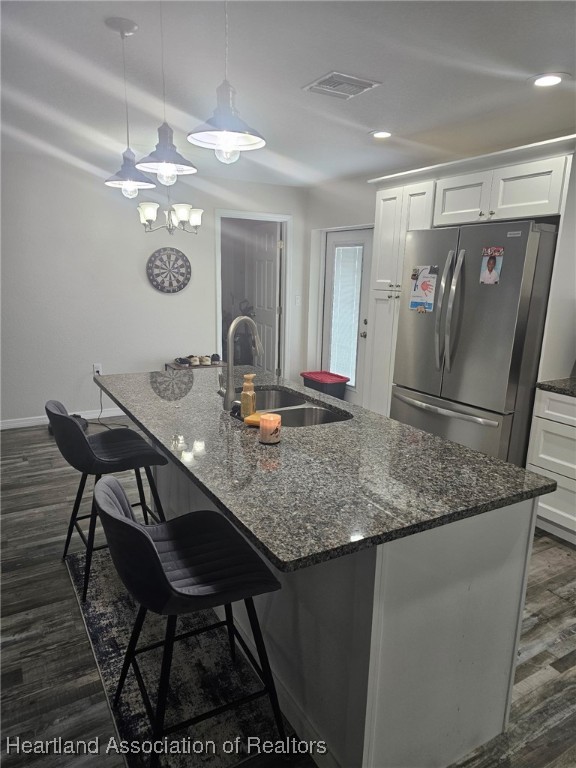 565 Stephens Road Wauchula, FL 33873 - Photo 11 of 36 a kitchen with stainless steel appliances granite countertop a table chairs in it and wooden floor