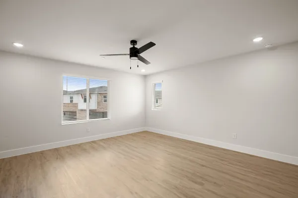 a view of an empty room with a window and wooden floor