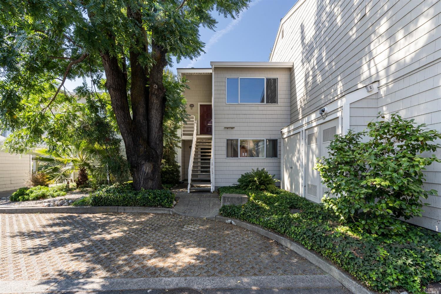 433 Enfrente Road, Unit B Novato, CA 94949 - Photo 1 of 1 a view of a white house next to a yard with plants and trees