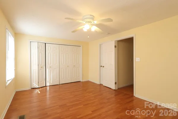 a view of an empty room and window with wooden floor