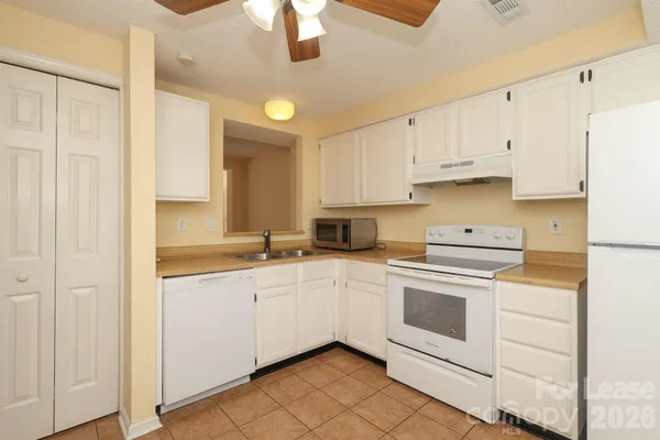 a kitchen with white cabinets and white appliances