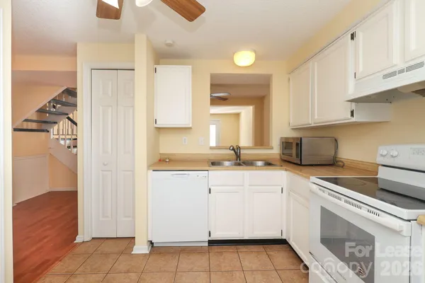 a kitchen with white cabinets and appliances