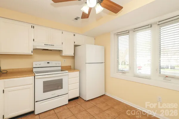 a kitchen with white cabinets and white appliances