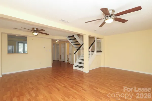 a view of a livingroom with a ceiling fan and wooden floor