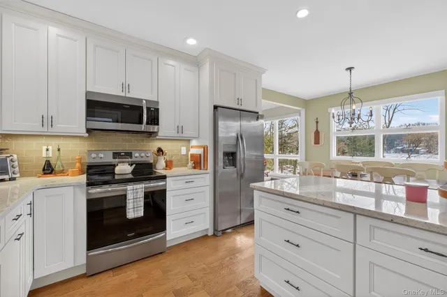 a kitchen with stainless steel appliances granite countertop a stove a sink and a refrigerator