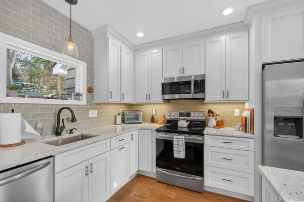 a kitchen with white cabinets stainless steel appliances and sink