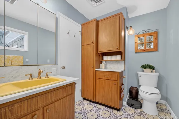 a bathroom with a granite countertop toilet sink and mirror