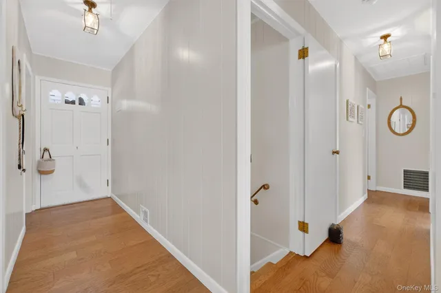 a view of a hallway with wooden floor and staircase