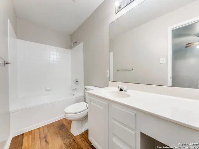 a bathroom with a sink a toilet and a large mirror