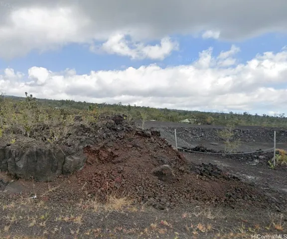 a view of a dry yard with wooden fence