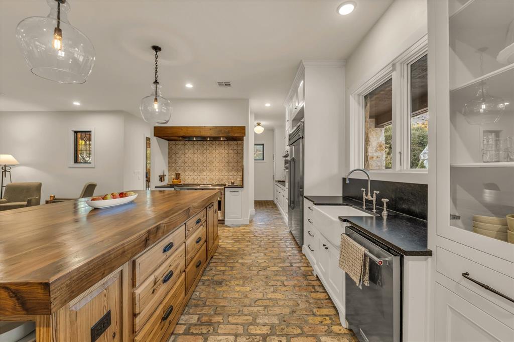 22 Samaritan Way Waco, TX 76705 - Photo 11 of 38 a kitchen with kitchen island a sink stove and wooden floor