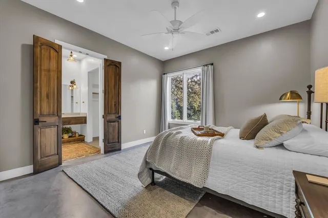 a bedroom with a large bed and a chandelier